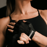 Person wearing black workout gym gloves with 'RooGrips' branding.